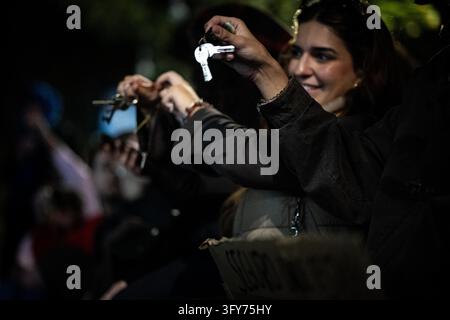 A participant raises a house key during a housing rights assembly at ...