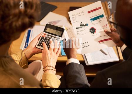 Female Client and Financial Consultant Calculating Energy Bills with Calculator Stock Photo