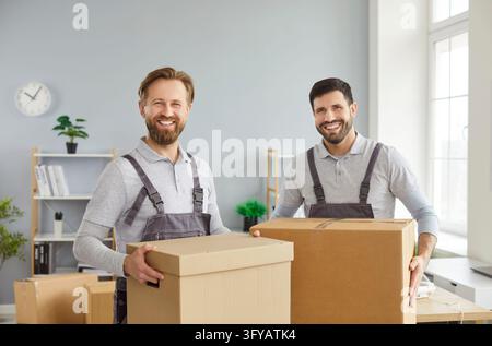 Happy moving delivery service, male movers team moving cardboard boxes, loading, unloading Stock Photo