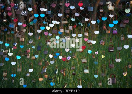 Kolobrzeg, Poland - 06.06.2026 A chain-link metal mesh fence, to which many ''Love padlocks'' (including some shaped like hearts) are attracted Stock Photo
