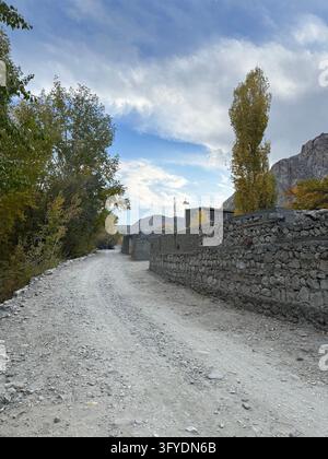 Dirt road winding through a rural mountain village landscape Stock Photo