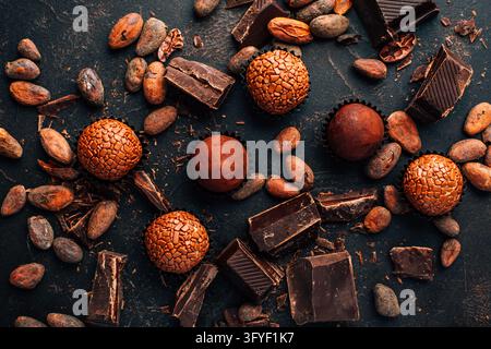 Assorted chocolate truffles and dark chocolate pieces with scattered cocoa beans Stock Photo