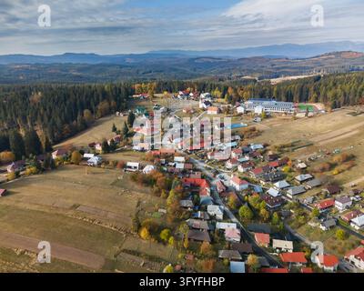 Aerial view of the village of Lom nad Rimavicou with traditional houses, forests, and rolling hills in the Low Tatras, Lom nad Rimavicou, Banska Bystr Stock Photo