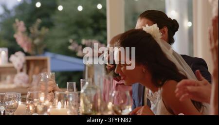 Guests enjoying lively conversation and laughter at wedding reception dinner table. Celebration, gathering, toasting, festive, merry, interaction Stock Photo