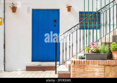 Traditional blue wooden door set in a whitewashed building in the picturesque old town of Mojacar, Almeria, Andalusia, Spain. Stock Photo