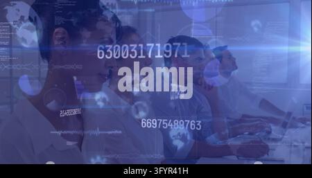Four men in light shirts facing workstations with data graphics covering blue control room. Technology, teamwork, monitoring, futuristic, digital, int Stock Photo