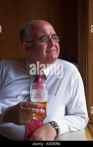 Mature businessman enjoying a lunchtime pint in the pub