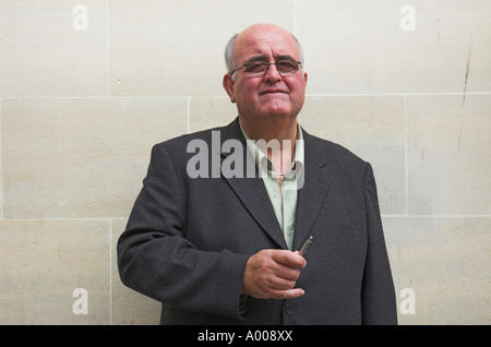 Portrait of a casually dressed businessman standing against a stone wall Stock Photo