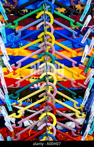a row of coloured coat hangers with brightly coloured sarongs on them for sale in ubud market bali Stock Photo