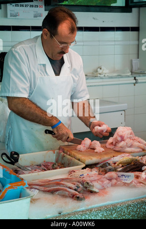 dh Claustre del Carme MAHON MENORCA New indoor fish food market stall shop fishmonger shopkeeper preparing fish local people mao Stock Photo