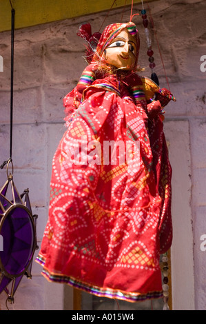 Traditional hanging Indian dolls wearing vibrant red patterned dresses, a classic cultural craft from Rajasthan, India. Stock Photo