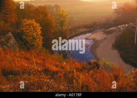 Glowing sunrise looking over farmland and a rural creek as seen from above on bluffs in autumn, Cedar Creek, Missouri, USA Stock Photo