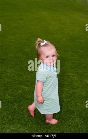 Fourteen Month Old Girl on Grass in Park Stock Photo