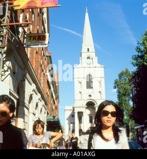 Chinese woman with sunglasses walking along Brushfield Street with a view of Hawksmoor Christchurch London E1 UK Stock Photo