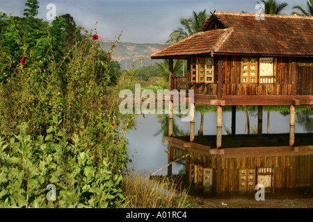 Woodden house made of wood standing on stilts in pond full of water and green plants , Eco resort , Neral , Maharashtra , India Stock Photo