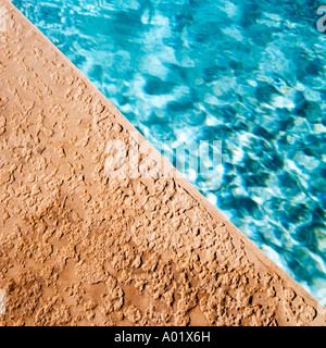 Blue water at the edge of a swimming pool Stock Photo