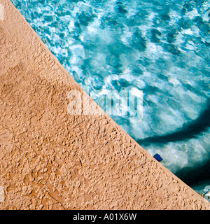 Blue water at the edge of a swimming pool Stock Photo