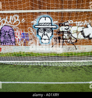 Graffiti on a wall behind a goal netting Islington North London England UK Stock Photo