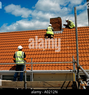 Roofing tilers lay tiles on a roof Stock Photo