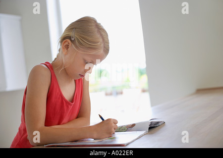 Girl doing homework in kitchen at table Stock Photo