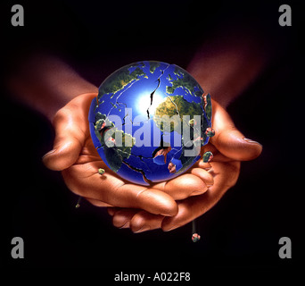 hands holding planet earth breaking in pieces Stock Photo