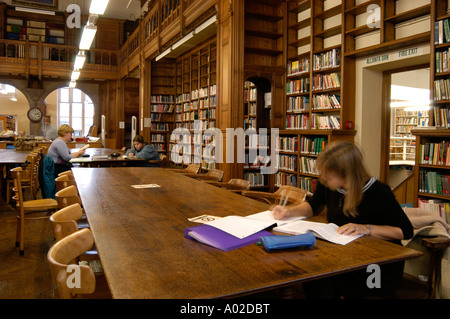 Three students working sitting at large wooden tables in the library of the Old College Aberystwyth University Wales UK Stock Photo