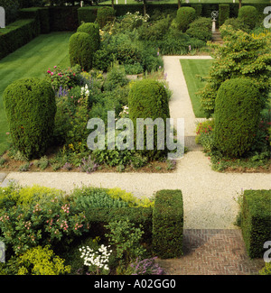 Birds-eye view of clipped yew trees and gravel paths through herbaceous borders in large country garden Stock Photo