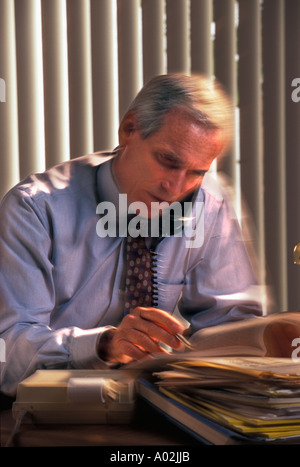 Caucasian businessman working desk talking on phone Stock Photo
