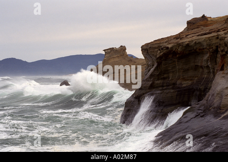 Pacific Ocean surf crashes against weathered sandstone cliffs at Cape Kiwanda Pacific City Oregon Stock Photo