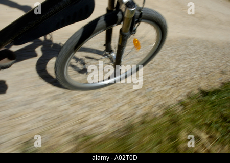 Front wheel of a mountain bike on a dirt road Stock Photo