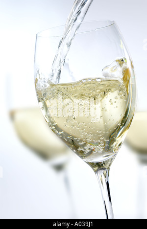 WHITE WINE BEING POURED INTO A GLASS Stock Photo