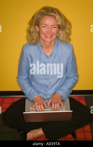Woman sitting on floor with laptop Stock Photo