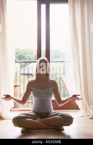 Young female sitting in a yoga position Stock Photo