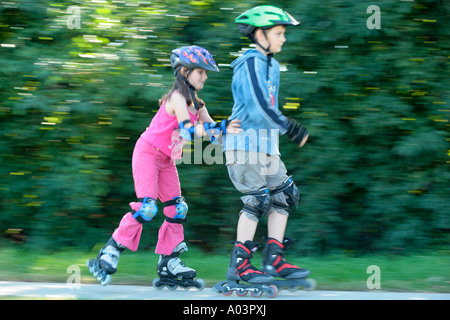 young skater pushing her big brother Stock Photo