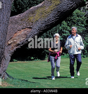 MATURE COUPLE JOGGING IN PARK Stock Photo