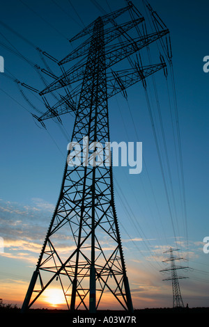 the sun setting behind a power pole Stock Photo
