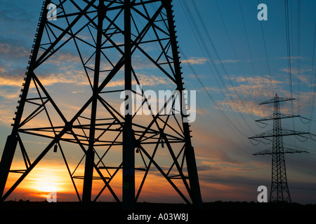 the sun setting behind a power pole Stock Photo
