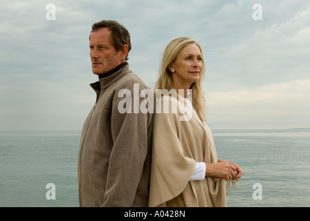 mature couple standing back to back having had an argument Stock Photo