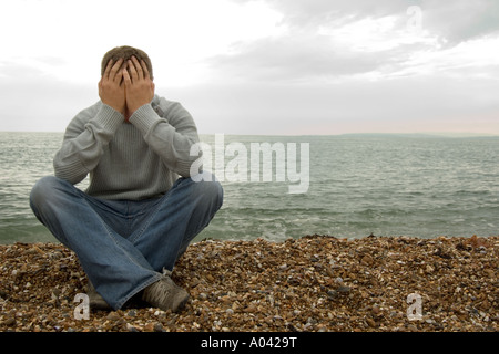 young man with his head in his hands Stock Photo