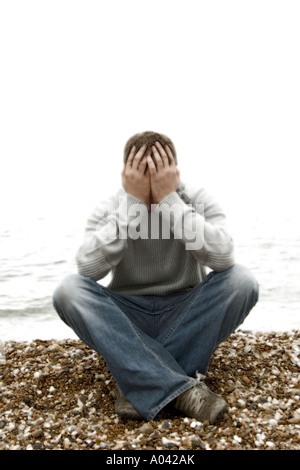 young man with his head in his hands Stock Photo