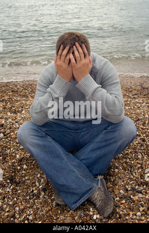 young man with his head in his hands Stock Photo
