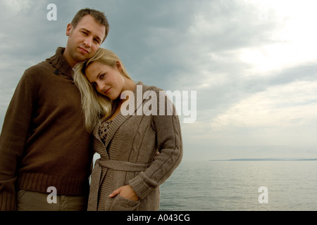 young couple cuddling by the sea Stock Photo