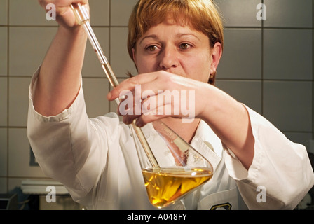 Scientist in a Laboratory Taking a Sample from a Glass Conical Flask Stock Photo