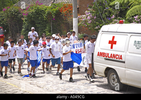 GUATEMALA Panajachel Guatemalan school children run behind a flaming torch bearer Stock Photo