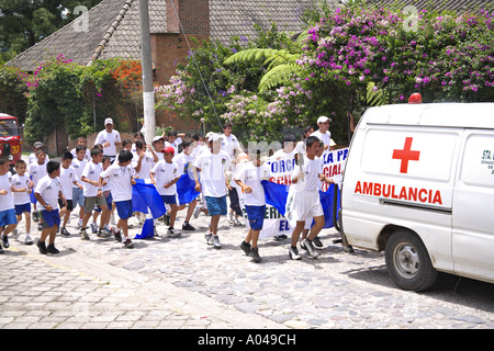 GUATEMALA Panajachel Guatemalan school children run behind a flaming torch bearer Stock Photo