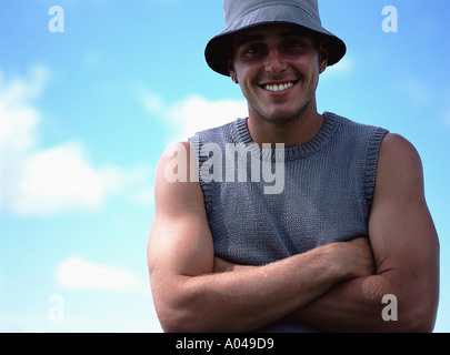 Portrait of a young man with arms folded wearing a sunhat Stock Photo