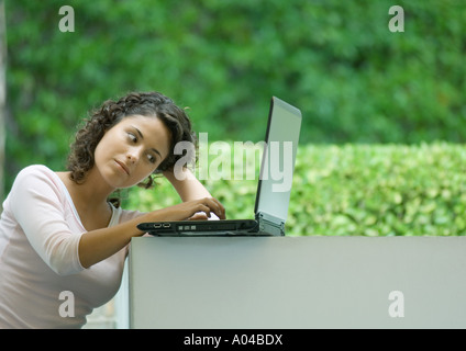 Woman using laptop outdoors Stock Photo