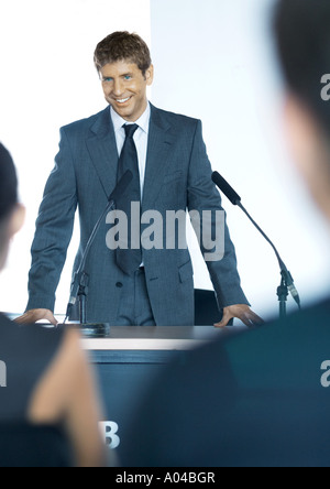 Speaker standing next to microphones during seminar Stock Photo