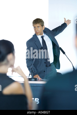 Speaker standing next to microphones during seminar Stock Photo