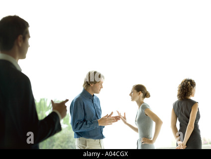 Man watching couple talking during cocktail party Stock Photo